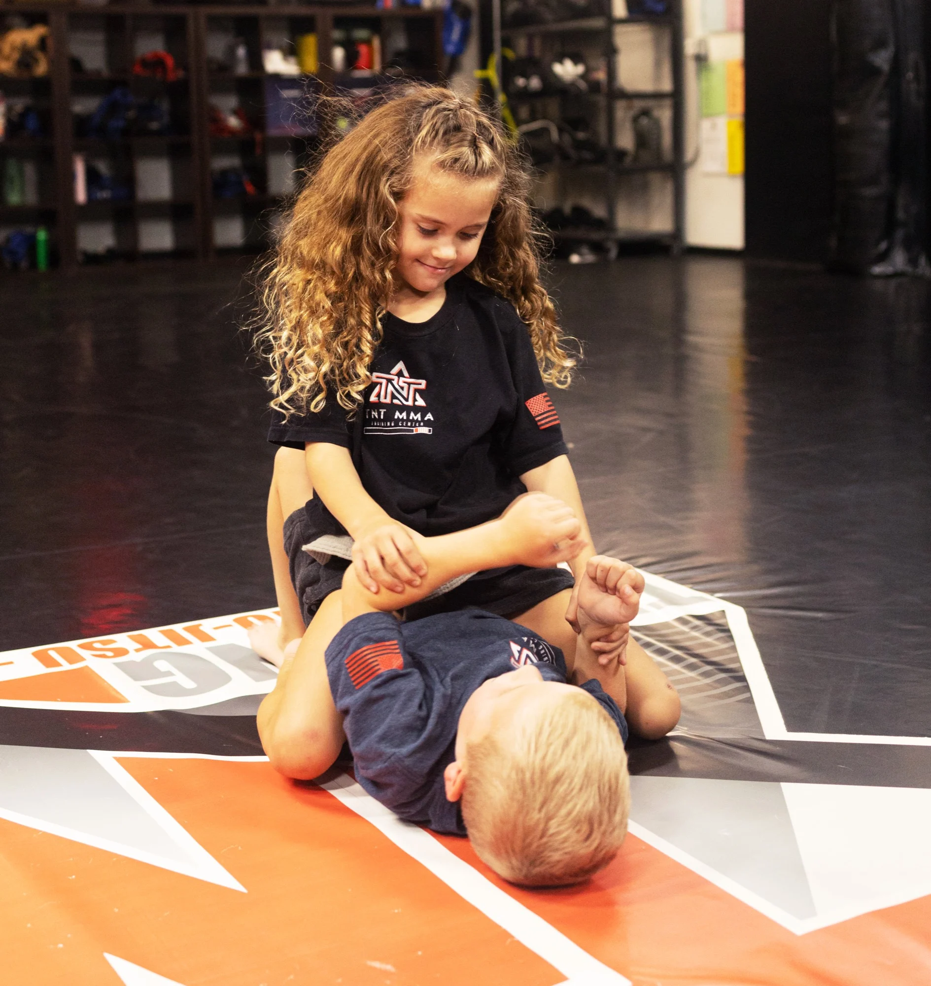 Two young children drilling No-Gi Jiu-Jitsu on the mats at TNT MMA Training Center in Phoenix, one controlling from top position