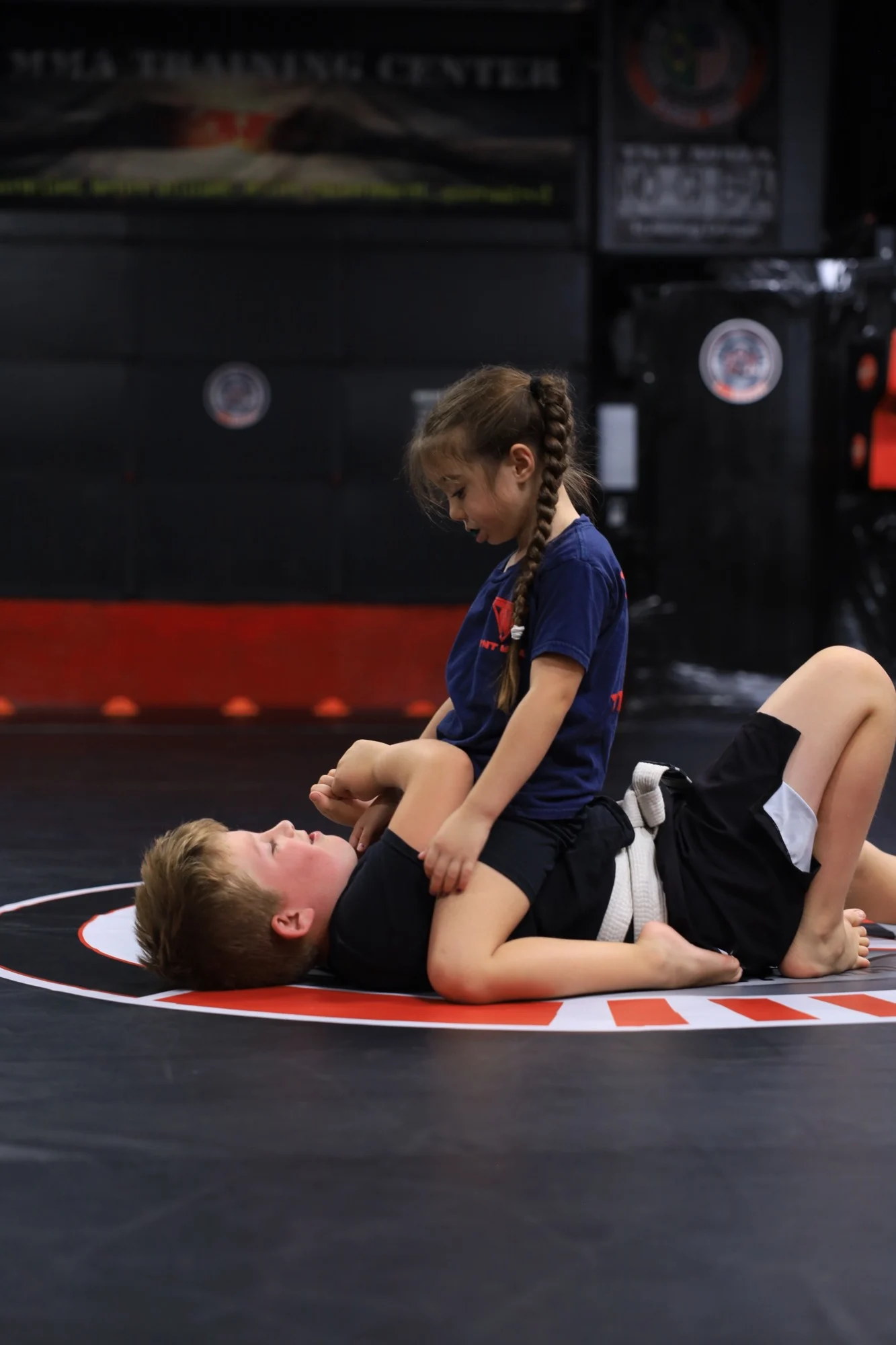 A young girl holding the mount during a kids No-Gi Jiu-Jitsu class at TNT MMA Training Center in Phoenix, Arizona